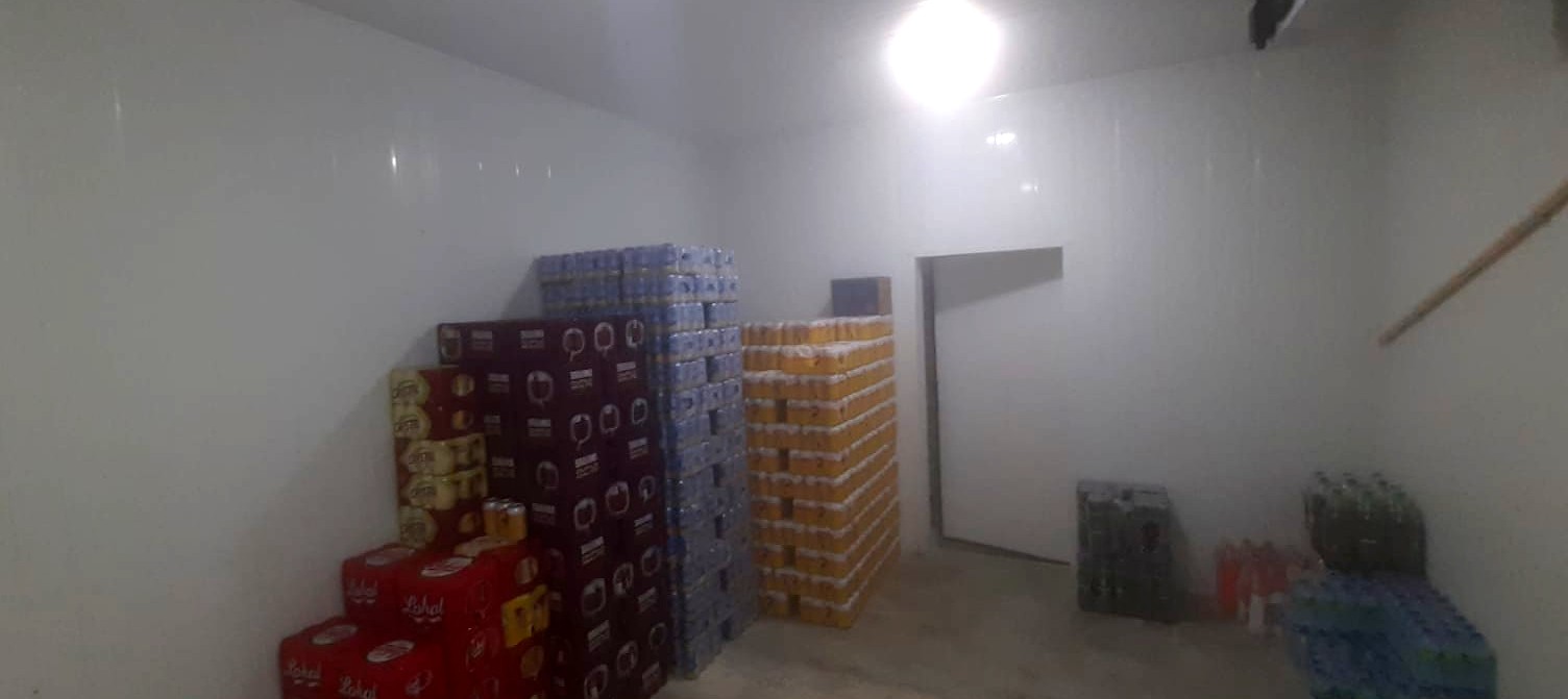 Interior de câmara fria com caixas empilhadas e estoque organizado