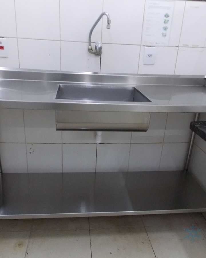 Bancada em aço inox com cuba e torneira alta, em cozinha azulejada