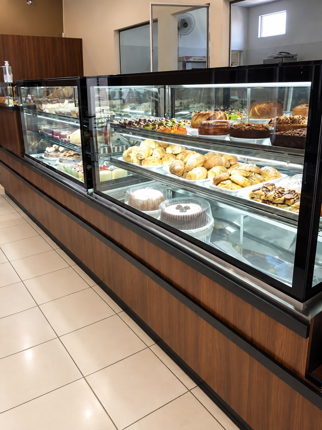 Vitrine refrigerada de doces e salgados no balcão de atendimento da loja