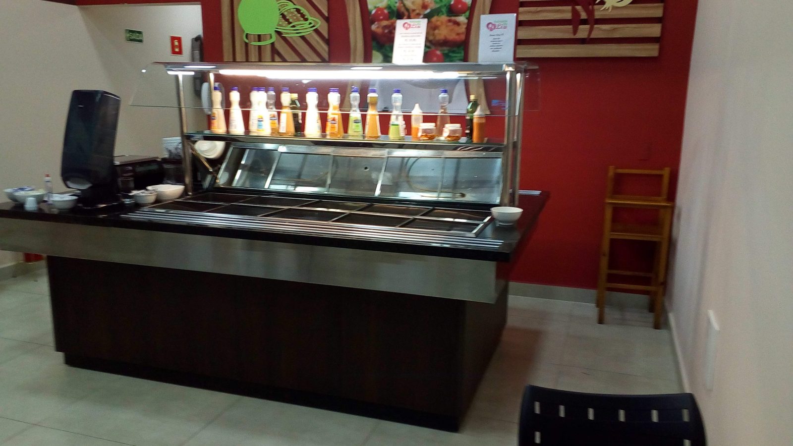 Pista de rotisseria com frente amadeirada, tampo de granito e estrutura superior iluminada