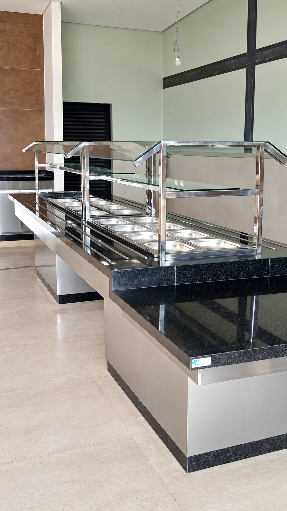 Balcão em aço inox com portas, na área de apoio do restaurante